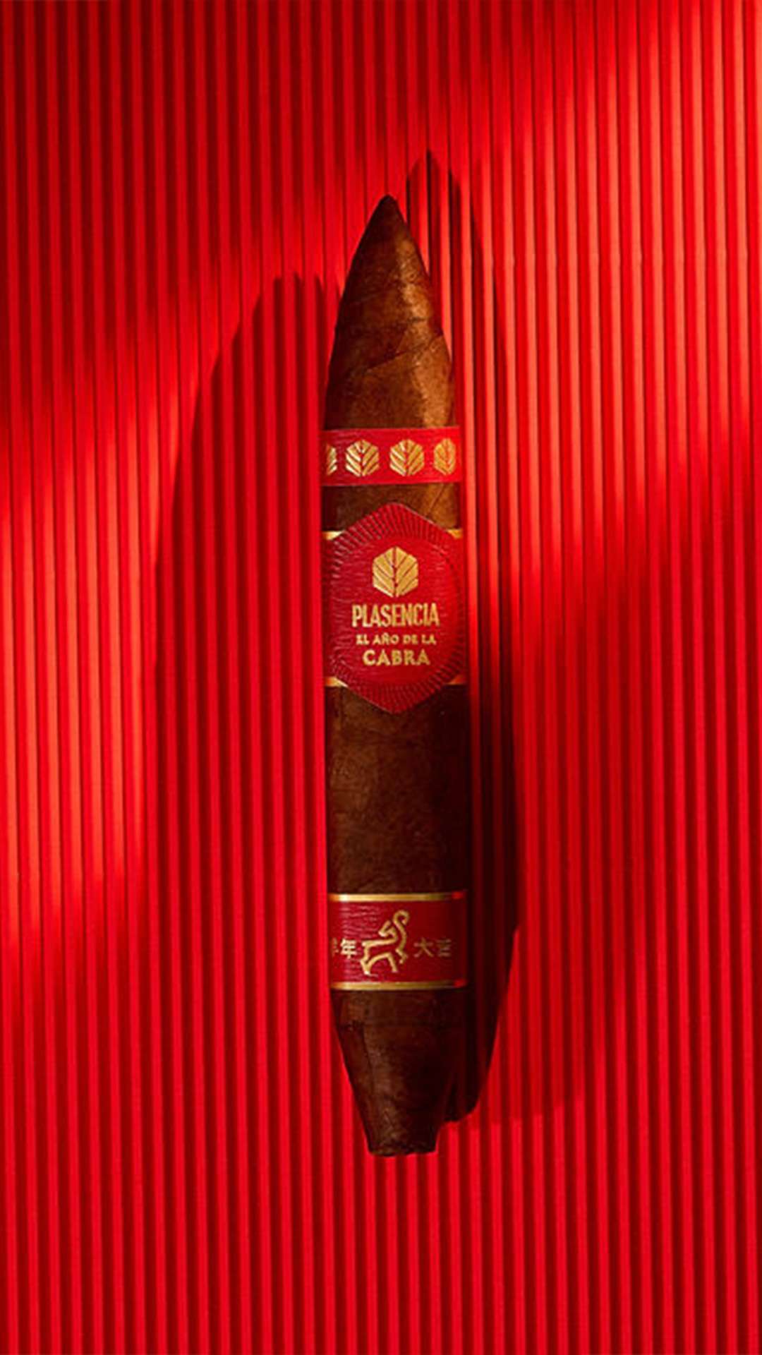 Plasencia El Año de la Cabra Perfecto Figurado against a red ribbed backdrop