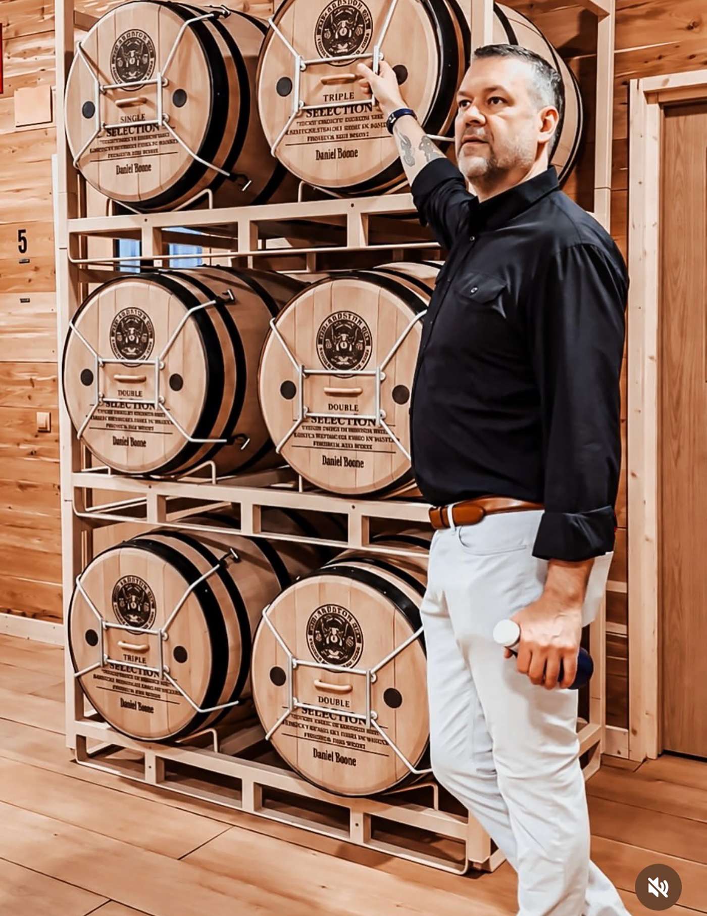 A guide stands beside barrels in Selected Tobacco's long-term aging area